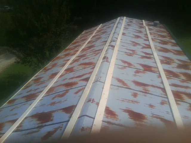 Rusted metal roof panels with new wood purlins before replacement — Storm Damage Roof Repair in Ira by Roofing Brothers