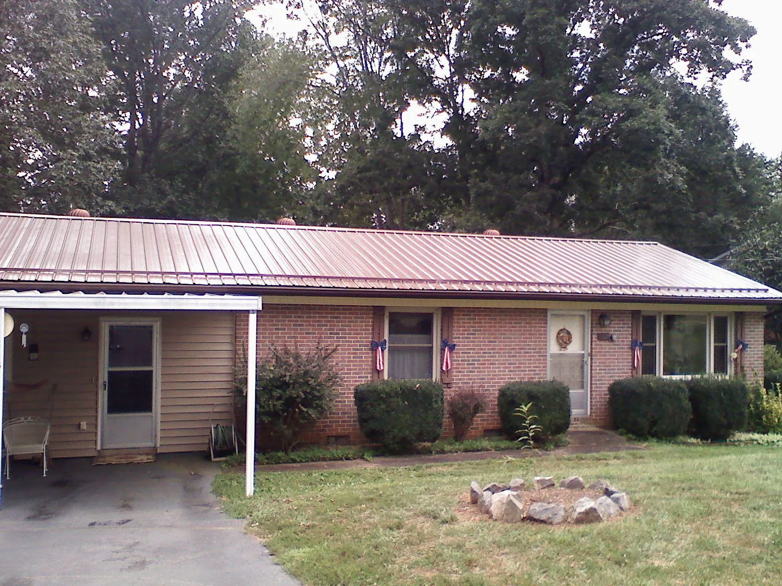 Bronze metal roof and carport on a brick ranch home — Roof Repair work by our crew in Ira